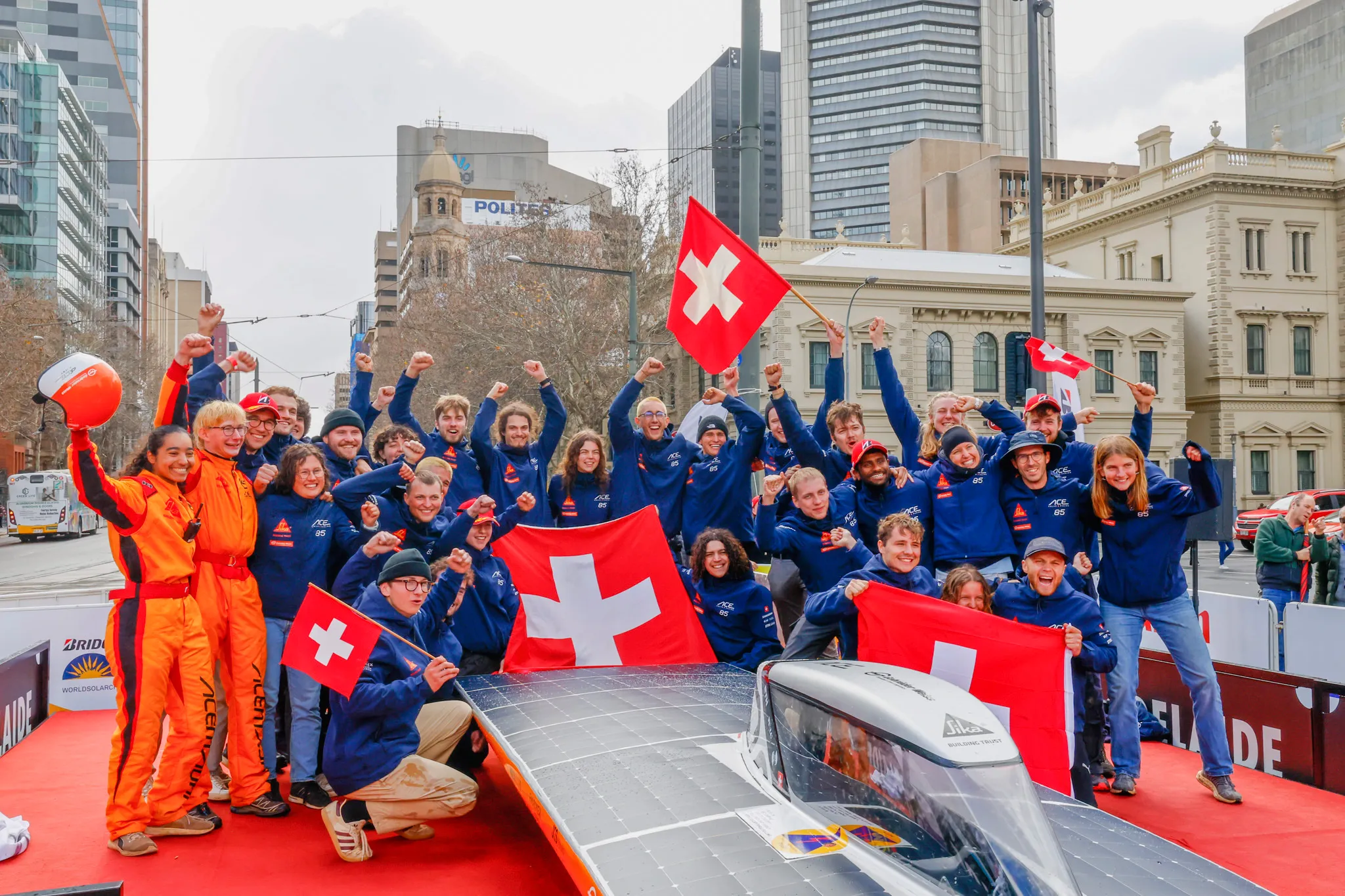The team celebrating with Swiss flags at the finish